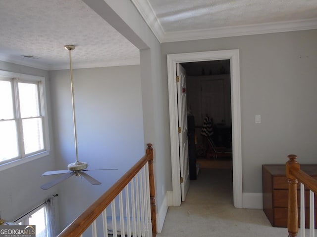 hallway with baseboards, ornamental molding, a textured ceiling, an upstairs landing, and light colored carpet