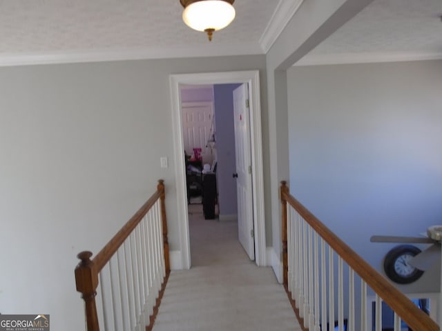 hallway featuring an upstairs landing, light carpet, and ornamental molding