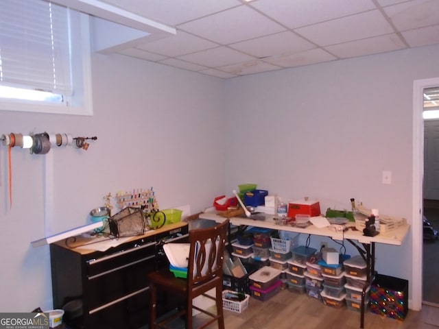 office with plenty of natural light, a paneled ceiling, and wood finished floors