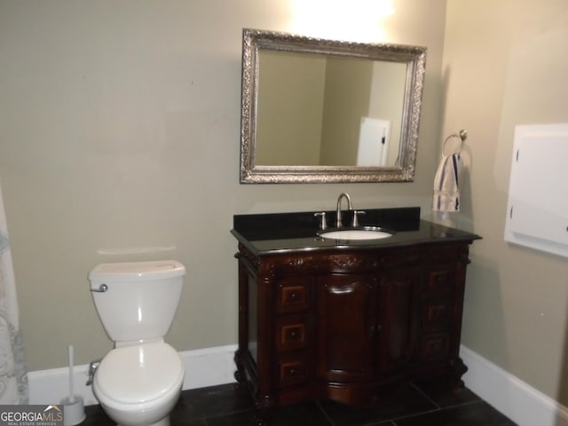 bathroom featuring baseboards, toilet, vanity, and tile patterned flooring