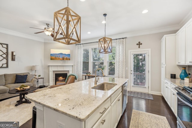 kitchen with a sink, stainless steel appliances, open floor plan, and ornamental molding