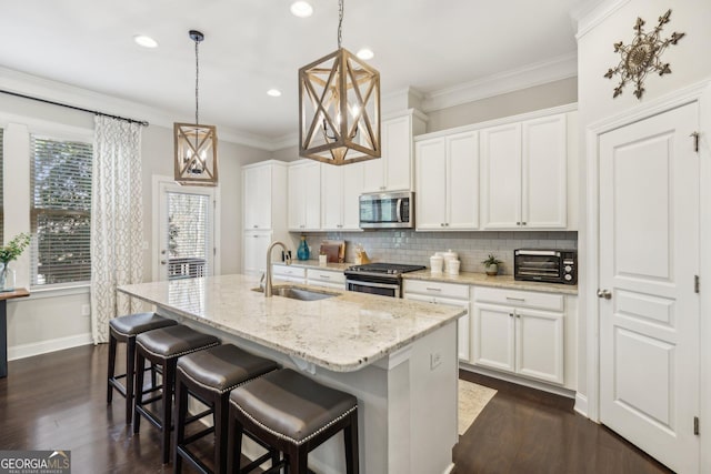 kitchen featuring tasteful backsplash, ornamental molding, stainless steel appliances, and a sink