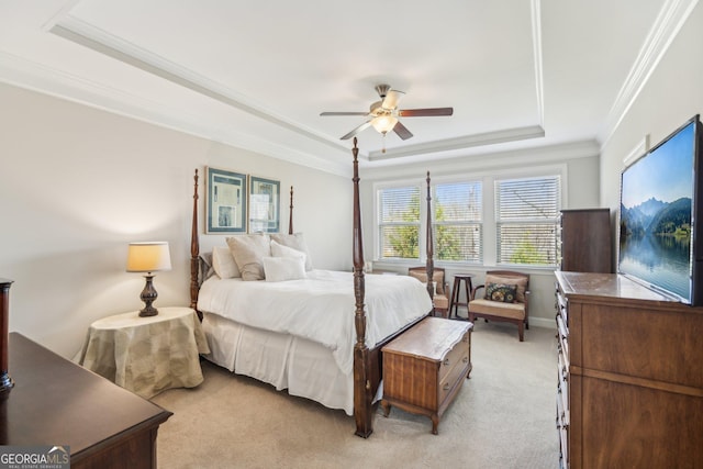 bedroom featuring a tray ceiling, light carpet, ceiling fan, and crown molding