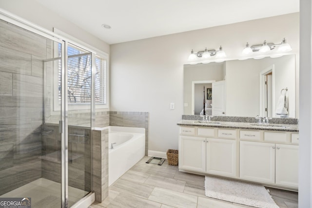 full bathroom with a sink, a stall shower, a bath, and double vanity