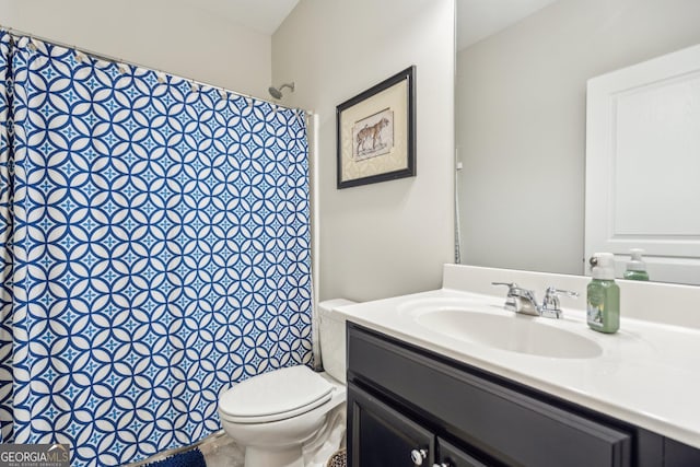 bathroom with curtained shower, toilet, and vanity