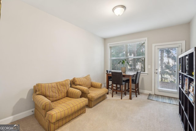 living area featuring carpet flooring and baseboards