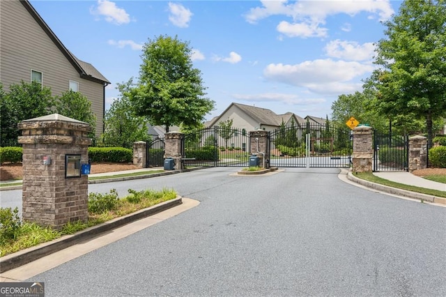 view of street featuring sidewalks, a gated entry, and a gate