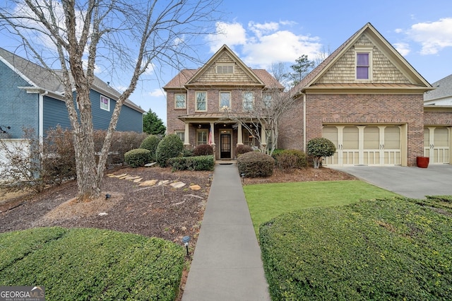 craftsman-style home with a garage, brick siding, concrete driveway, and a front lawn