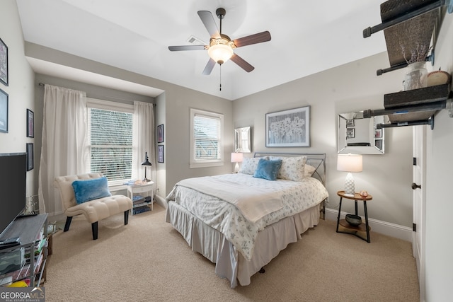 bedroom featuring baseboards, light colored carpet, and ceiling fan