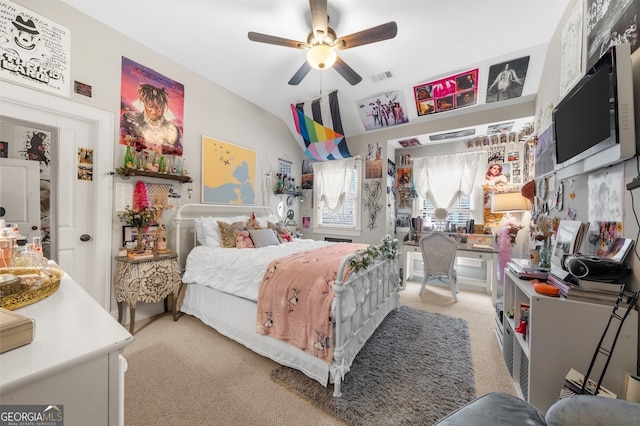 bedroom featuring visible vents, light colored carpet, and a ceiling fan