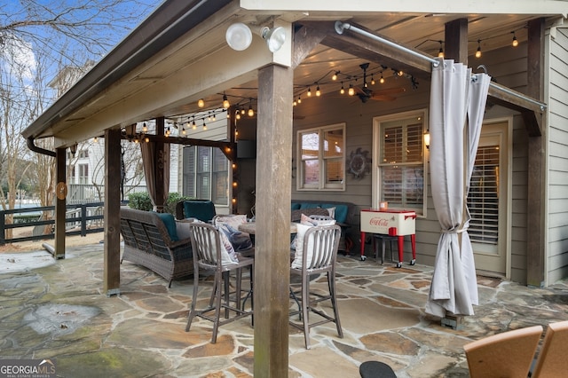 view of patio with an outdoor living space, ceiling fan, and fence