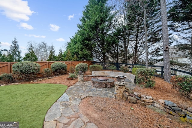 view of yard featuring a patio area, an outdoor fire pit, and a fenced backyard