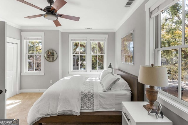 bedroom with visible vents, carpet flooring, crown molding, and baseboards