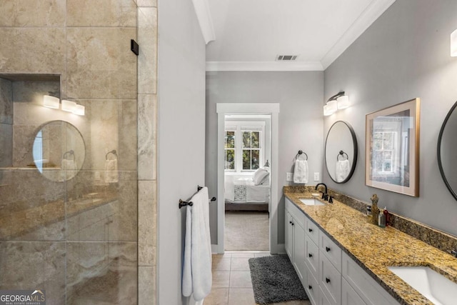 ensuite bathroom featuring a sink, visible vents, crown molding, and tile patterned flooring