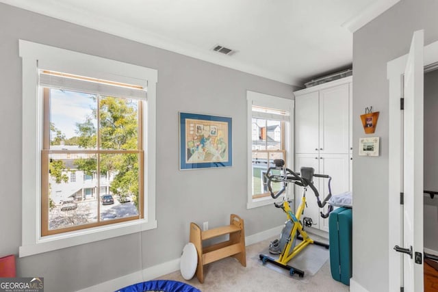 exercise area with visible vents, carpet, and baseboards