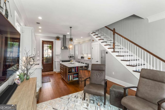 interior space with visible vents, dark wood-type flooring, recessed lighting, stairway, and crown molding