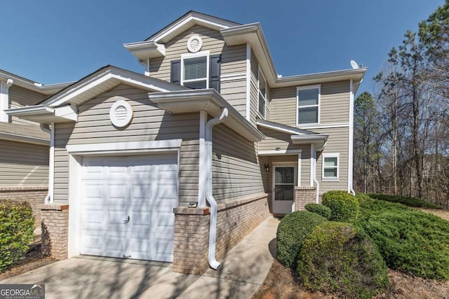 view of front of house featuring a garage, brick siding, and driveway