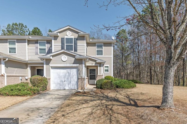 townhome / multi-family property with concrete driveway, an attached garage, and brick siding