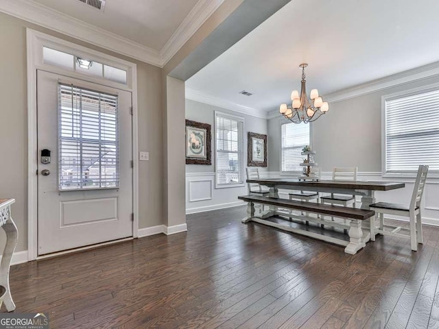 dining room featuring a notable chandelier, visible vents, wood finished floors, and ornamental molding