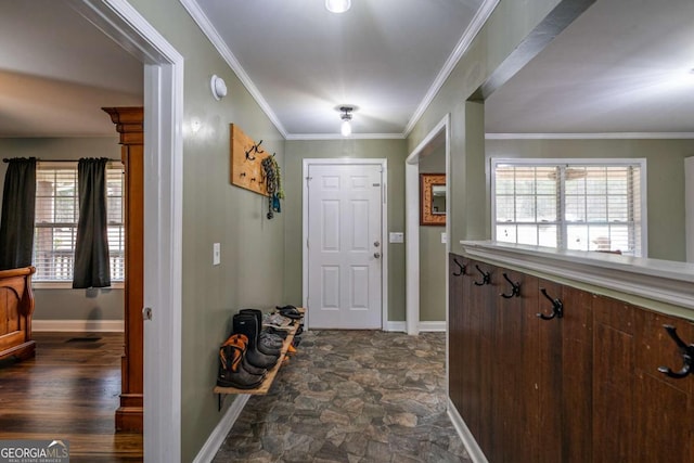 foyer featuring stone finish floor, baseboards, and ornamental molding