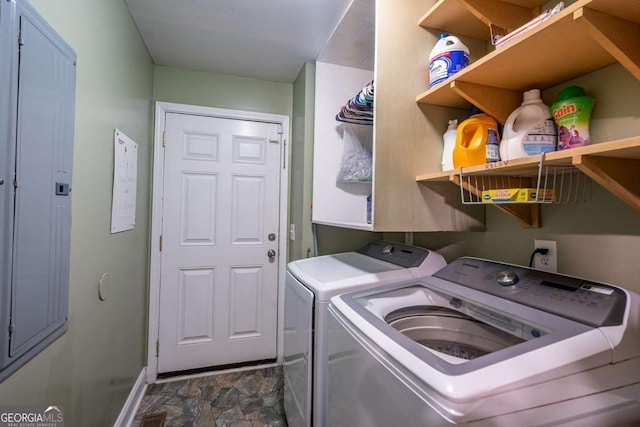 laundry area featuring washing machine and clothes dryer, laundry area, stone finish flooring, and baseboards