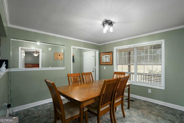 dining room featuring stone finish floor, crown molding, and baseboards