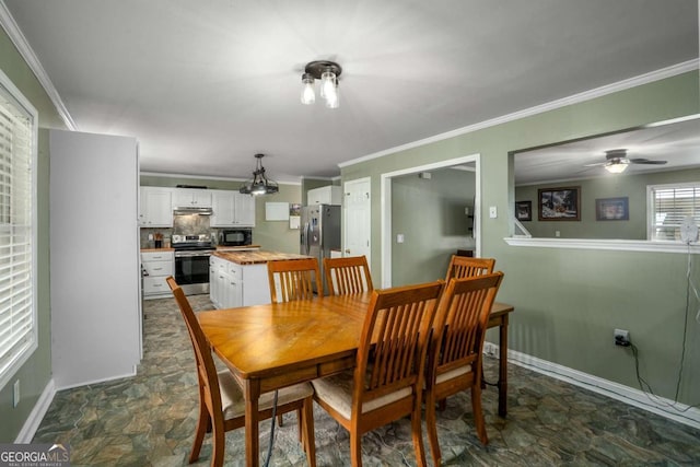 dining space featuring crown molding, baseboards, and stone finish flooring