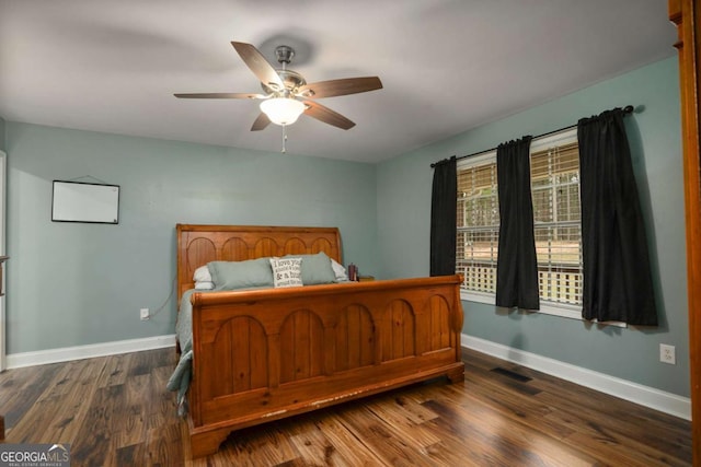 bedroom with a ceiling fan, visible vents, wood finished floors, and baseboards