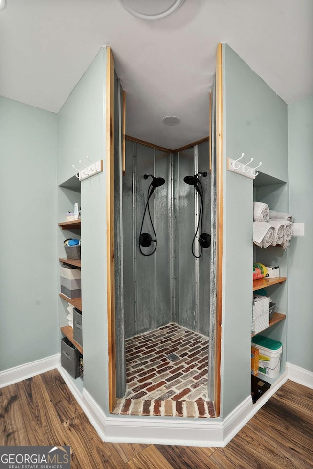 bathroom with a shower stall, baseboards, and wood finished floors