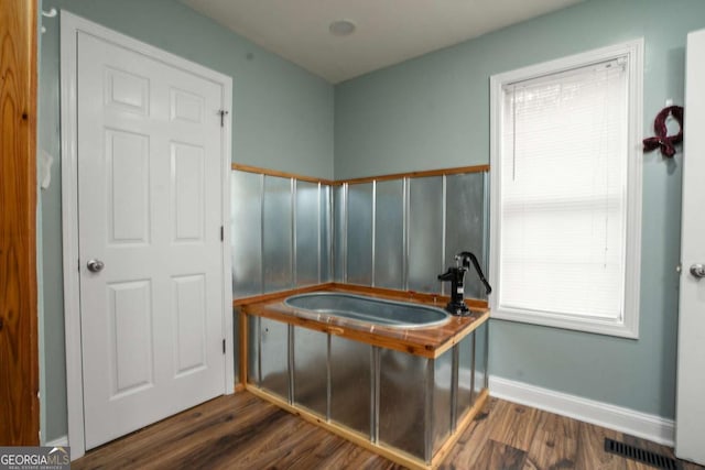 bathroom featuring baseboards, wood finished floors, visible vents, and a sink