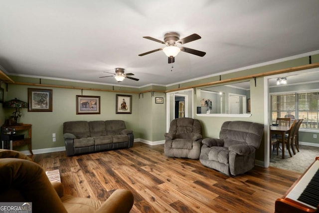 living room with baseboards, a ceiling fan, wood finished floors, and crown molding