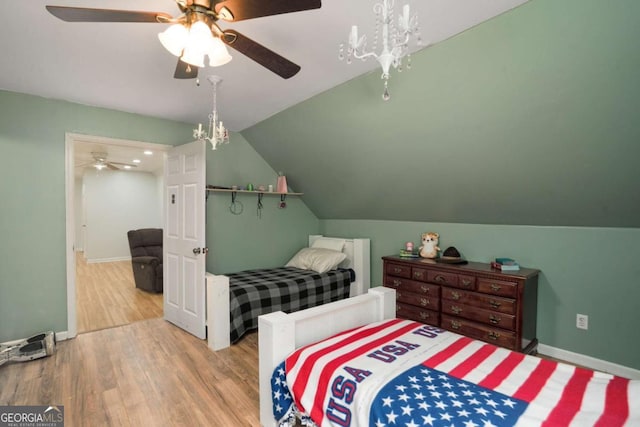 bedroom with ceiling fan, baseboards, wood finished floors, and vaulted ceiling