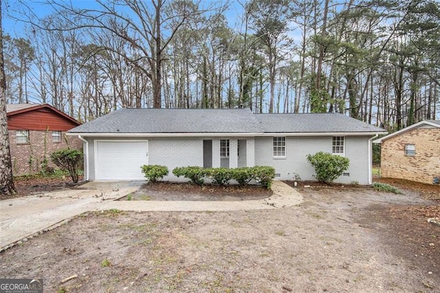 single story home featuring a shingled roof, an attached garage, driveway, and crawl space