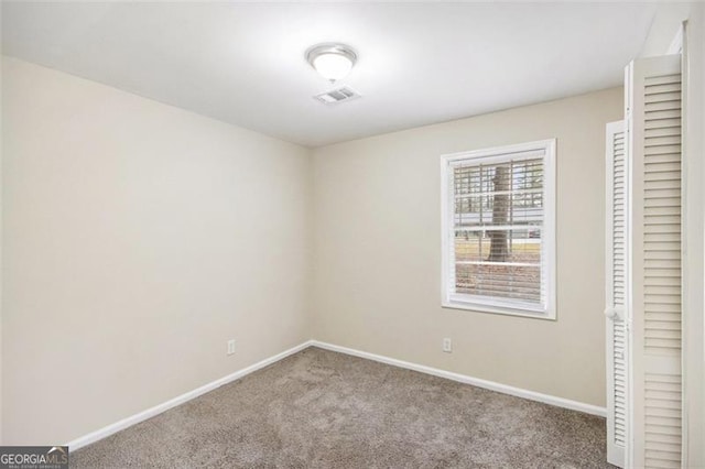 unfurnished room with visible vents, baseboards, and carpet