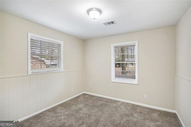 carpeted empty room with baseboards and visible vents