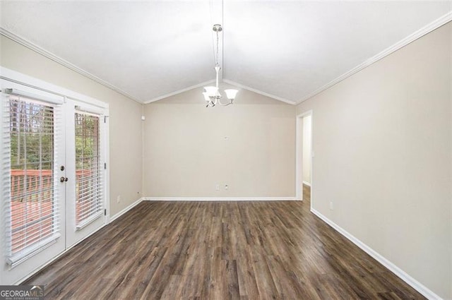 empty room featuring wood finished floors, baseboards, vaulted ceiling, crown molding, and a notable chandelier