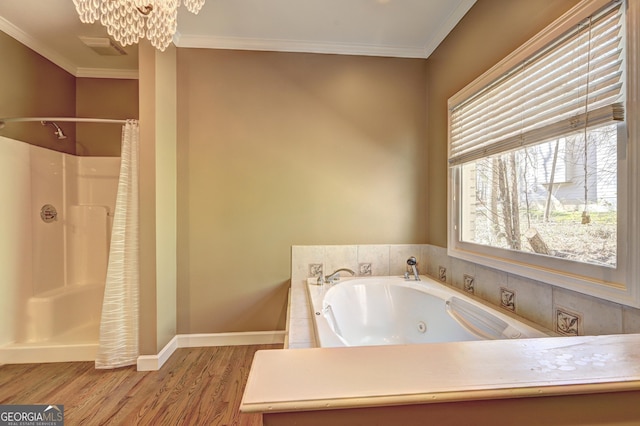 bathroom with a shower with shower curtain, wood finished floors, a tub with jets, ornamental molding, and a chandelier