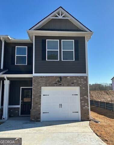 townhome / multi-family property with french doors, stone siding, a garage, and concrete driveway