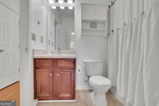 full bath featuring vanity, a shower with shower curtain, baseboards, tile patterned flooring, and toilet