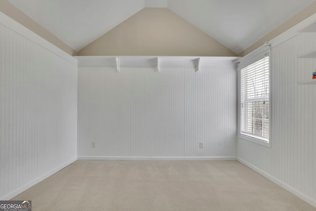 unfurnished room featuring light carpet and vaulted ceiling