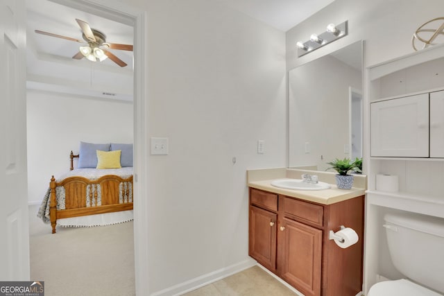 bathroom featuring baseboards, toilet, vanity, and ceiling fan