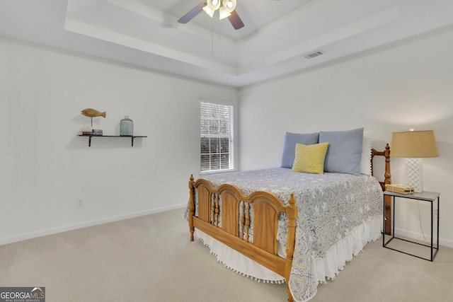 bedroom with visible vents, ceiling fan, baseboards, carpet, and a tray ceiling