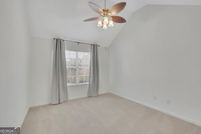 spare room with a ceiling fan, lofted ceiling, carpet, and baseboards