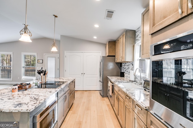 4864 Yeagar Rd, Douglasville, GA 30135 - kitchen with light wood-style floors, vaulted ceiling, visible vents, a sink, and stainless steel appliances