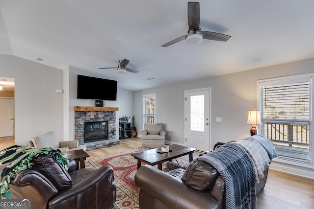4864 Yeagar Rd, Douglasville, GA 30135 - living room featuring visible vents, a stone fireplace, a ceiling fan, light wood finished floors, and lofted ceiling