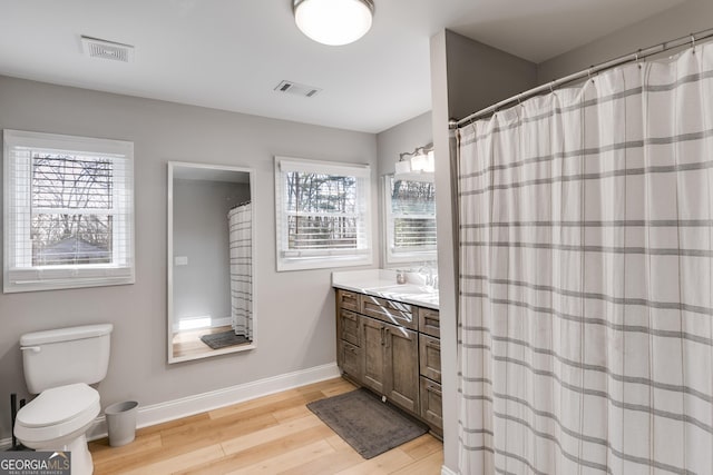 4864 Yeagar Rd, Douglasville, GA 30135 - full bath featuring vanity, baseboards, toilet, visible vents, and wood finished floors