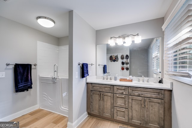 4864 Yeagar Rd, Douglasville, GA 30135 - full bath with a sink, baseboards, double vanity, and wood finished floors