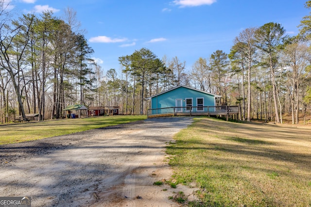 4864 Yeagar Rd, Douglasville, GA 30135 - view of front of house with gravel driveway, a wooden deck, and a front lawn