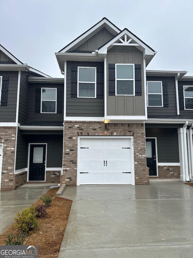 townhome / multi-family property with french doors, stone siding, concrete driveway, and an attached garage