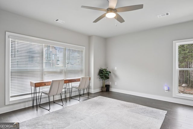 interior space featuring wood finished floors, baseboards, visible vents, and ceiling fan